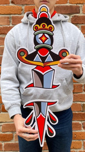 Image features the "No Fun®" Dagger PVC sign which was designed in collaboration with Brandon Ing.  It is a two part sign where one half is the blade, while the other is the handle.  The design is based off of traditional tattoo flash artwork.  The photo shows the product being held by the artist, to showcase the scale.