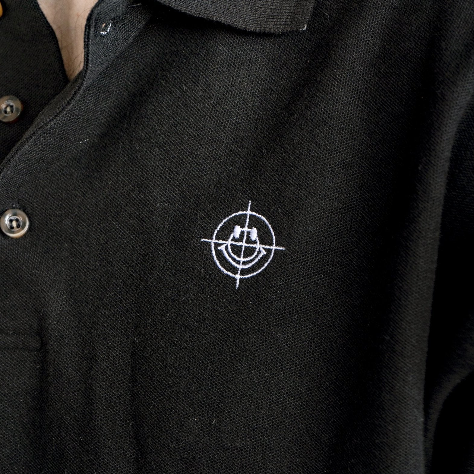 Detail of the embroidery on the black "Target" polo.