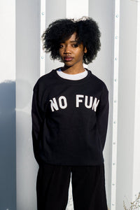 A female model wearing the original "NO FUN®" logo crewneck sweater. The sweater is black and features large white text that reads "NO FUN®".