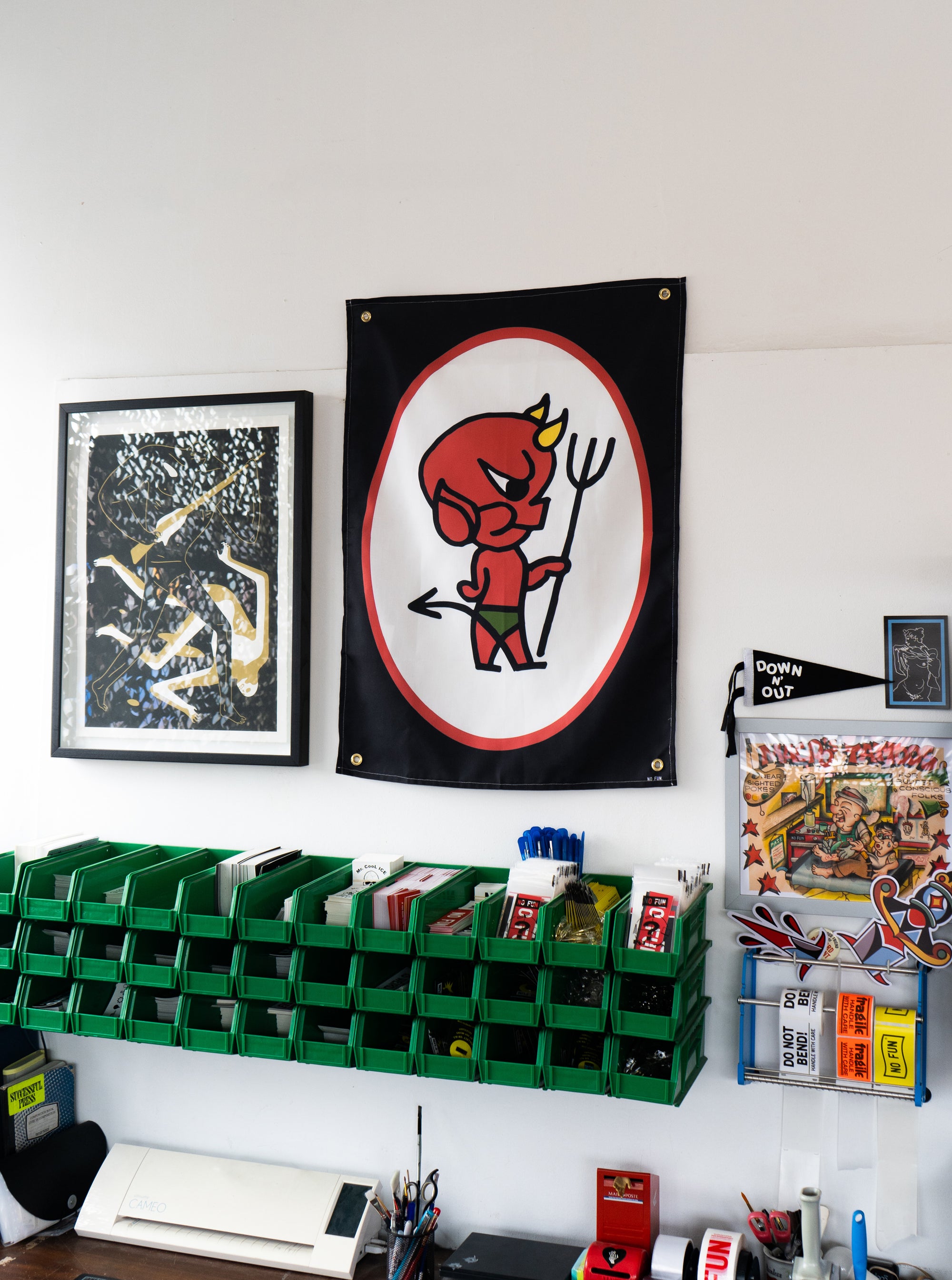The "Devil" Wall Tapestry hanging on the wall of a studio.  There are various prints and artwork surrounding it.
