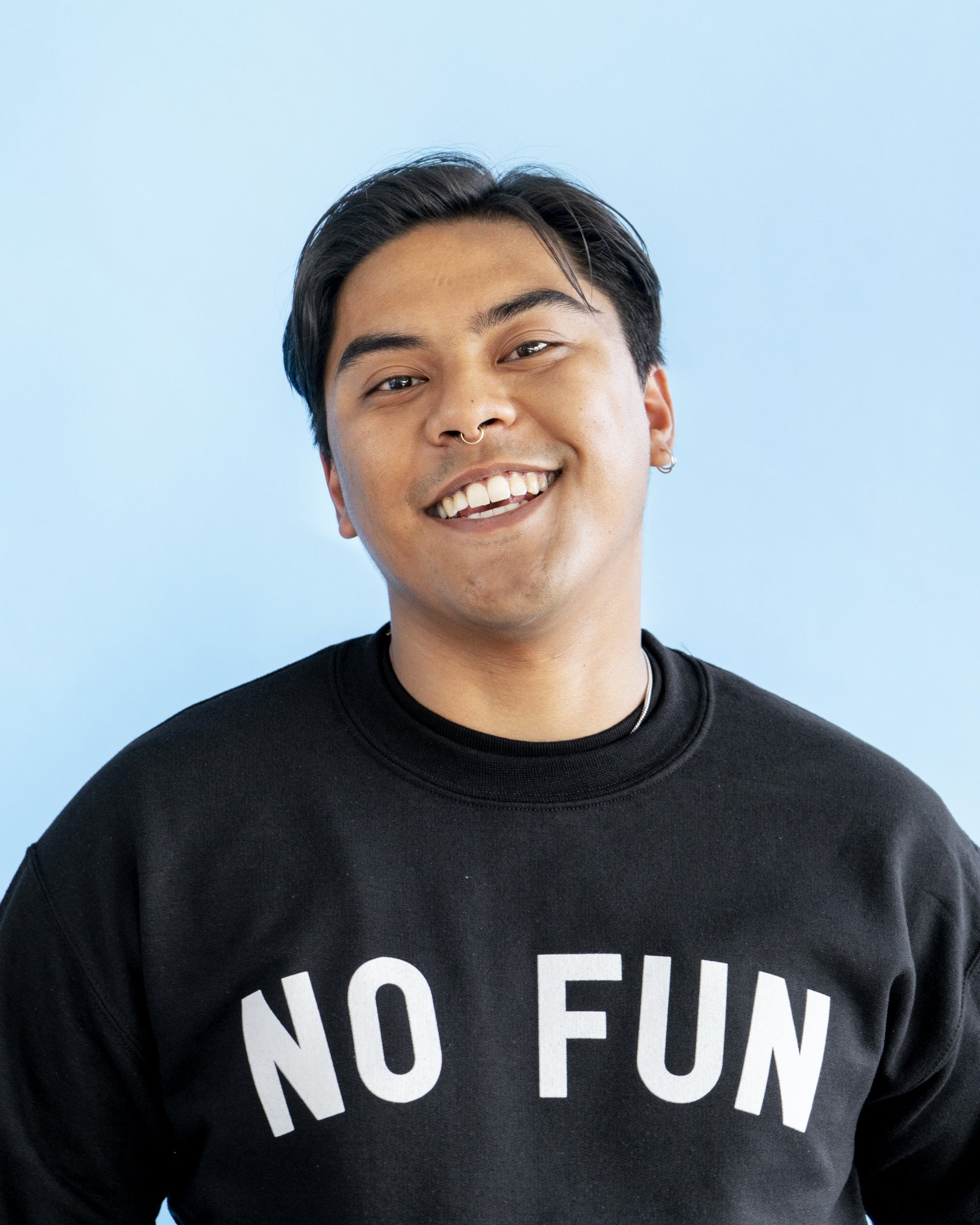 A male model wearing the original "NO FUN®" logo crewneck sweater. The sweater is black and features large white text that reads "NO FUN®".