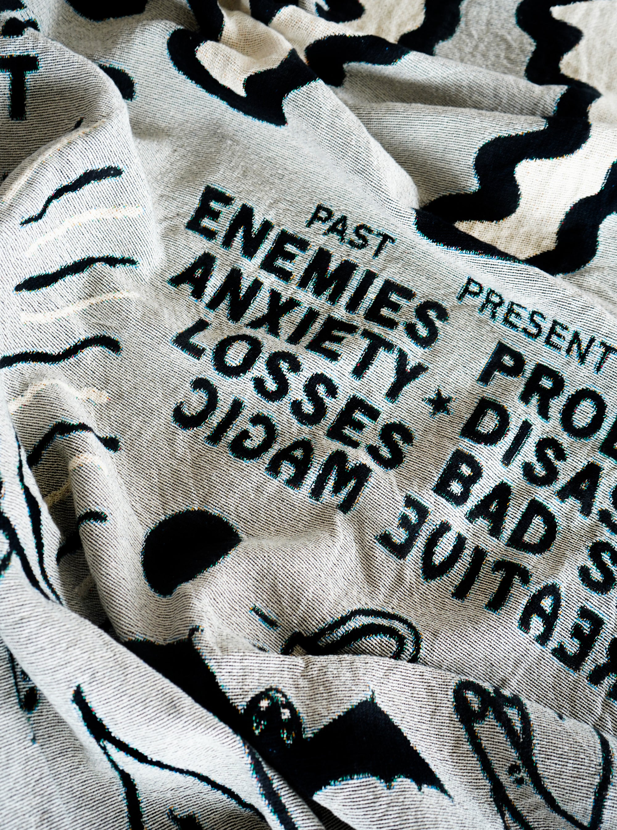 The "Alleged Jinx Removing" Woven Blanket photographed close up to showcase some of the other text that is included in the design.