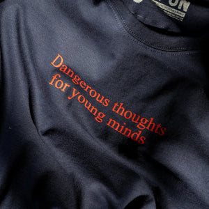 Detail of the red front print on the "Dangerous Thoughts" t-shirt. The print reads "Dangerous thoughts for young minds".