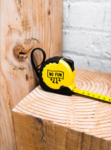 The "WORK" tape measure placed on a piece of wood. 