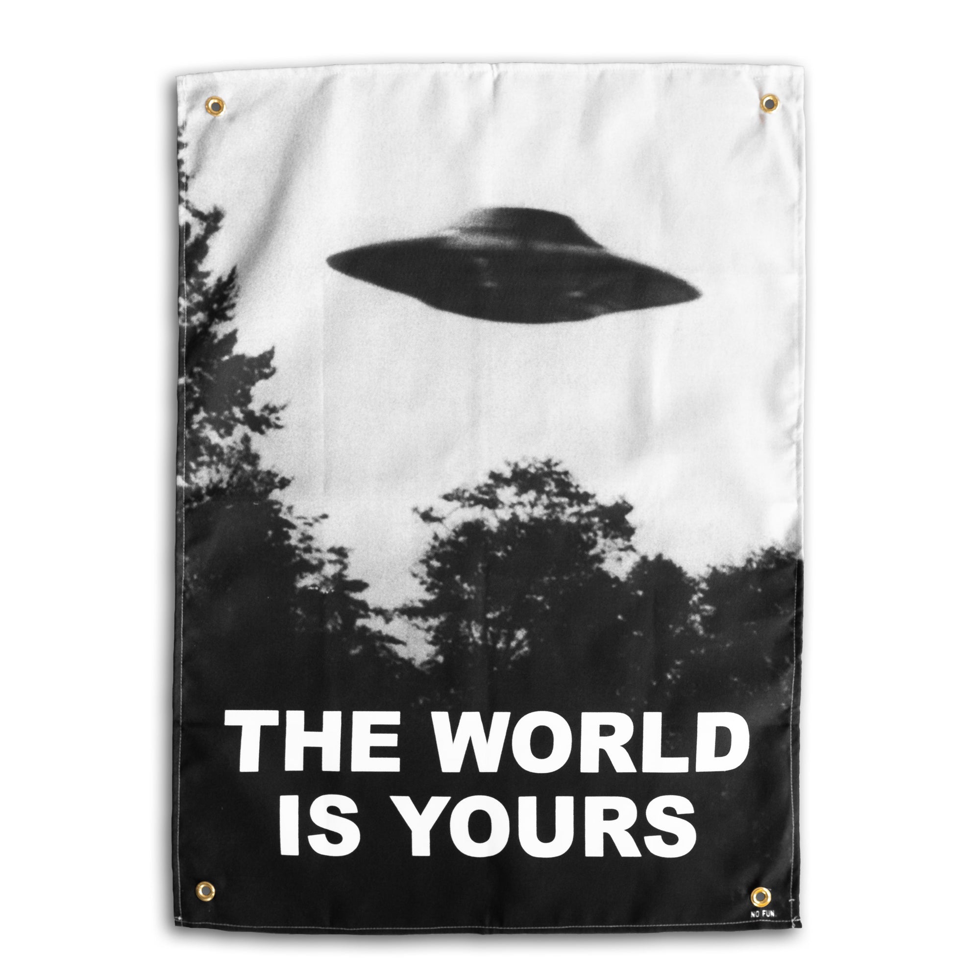 The "Blimp" Wall Tapestry by No Fun®.  Tapestry features a greyscale image of a UFO hovering above some trees.  The phrase "THE WORLD IS YOURS" is printed in large white letters underneath the UFO.  There is 1 brass grommet in each corner of the tapestry.