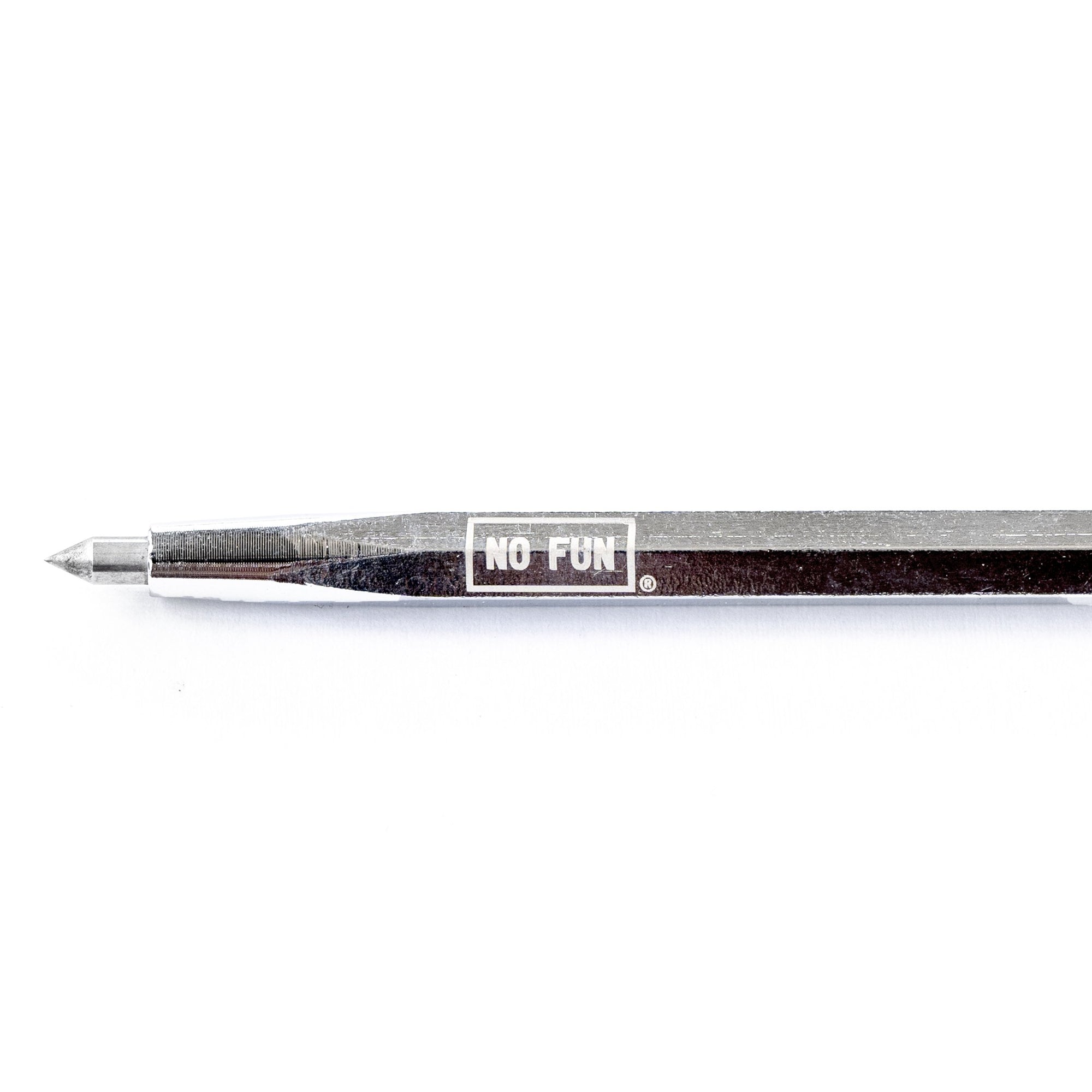 Carbide-tipped scribe pen made of extra tuff chrome steel. No Fun® logo detail engraved on the barrel. Perfect for marking all surfaces and graffiti writing. The scribe is photographed against a white backdrop.  Closeup detail of the carbide tip on the Everyday Carry scribe.