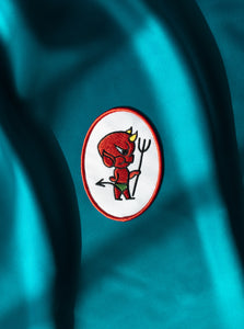 The "'Devil" Patch on teal fabric.