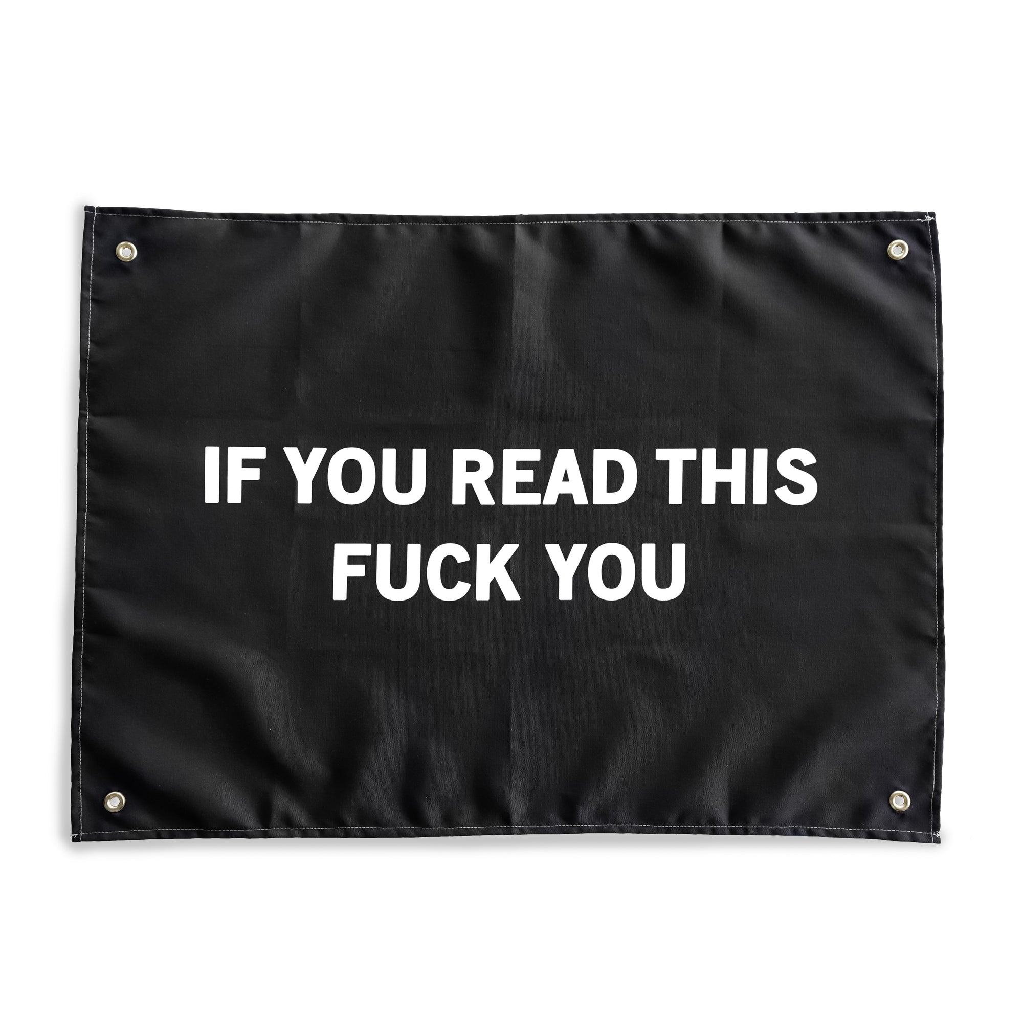 The "Read More" Wall tapestry by No Fun®.  Tapestry is black, and features the phrase "IF YOU READ THIS FUCK YOU" in large white letters.  There is 1 brass grommet in each corner of the tapestry.