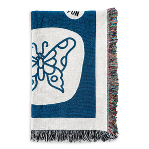 Detail photo of the No Fun® "Flash Sheet" Woven Blanket.  The product is folded and photographed against a white background.  This image showcases the detail of the butterfly which is found on the blanket, along with a portion of the "No Fun®" Logo.