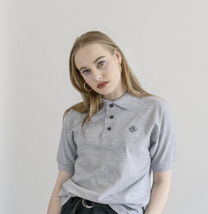 Woman wearing the grey "Target" polo, standing in a photo studio.