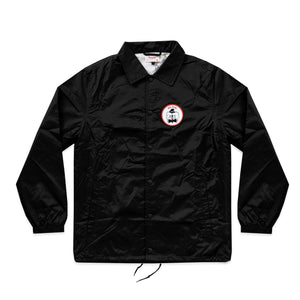 Photo of the "NO FUN®" X "Crawling Death" coaches jacket.  The jacket is black and features a circular breast patch of an executioner in black and white.  The patch also has a red "NO FUN®" logo and a red border.  The jacket utilizes snap closures and drawstring cord.