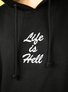 The "Life Is Hell" Hoodie by No Fun®, photographed to show the detail of the embroidered design.  The hoodie is black, with white embroidery that reads "Life is Hell" in a brush style font.  The embroidery is found on the front of the hoodie, in the center of the chest. 