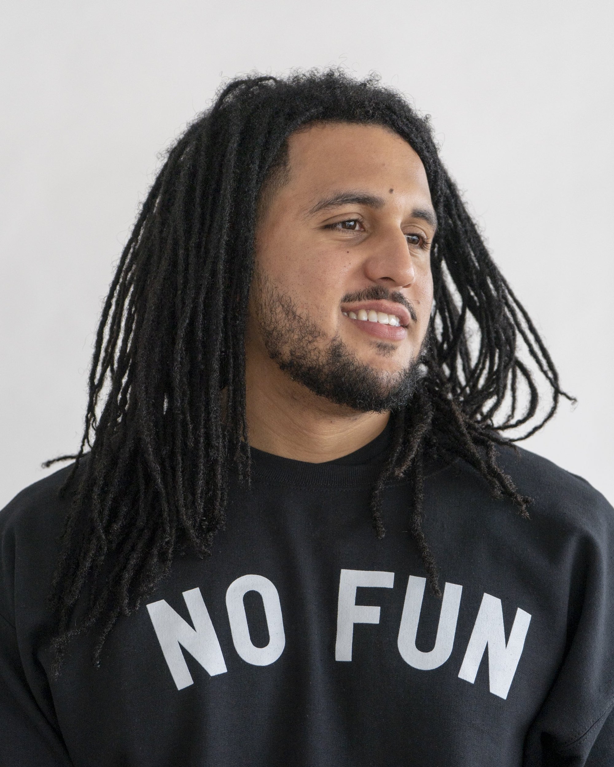 Amale model wearing the original "NO FUN®" logo crewneck sweater. The sweater is black and features large white text that reads "NO FUN®".