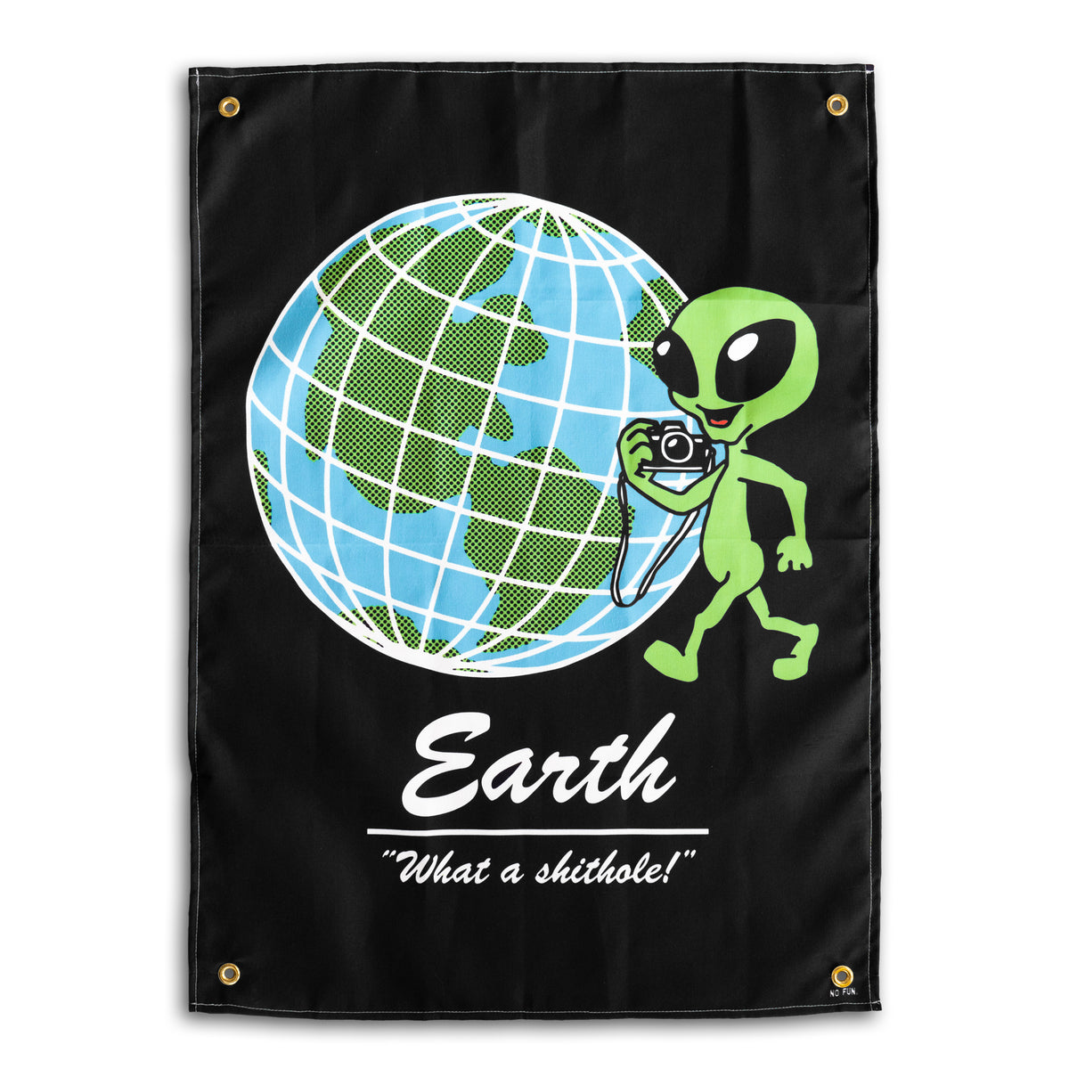 The "Tourist" Wall tapestry by No Fun®. Tapestry is black, and features a cartoon alien with a camera positioned in front of a globe.  The phrase "Earth 'What a shithole!'" is underneath the globe.  There is 1 brass grommet in each corner of the tapestry.