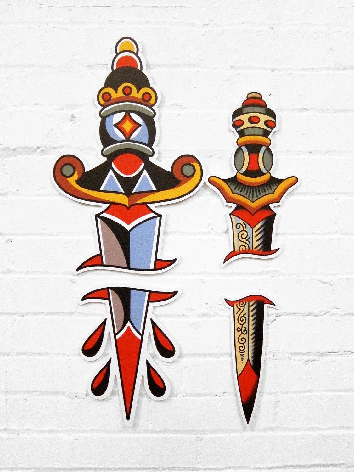 Image features the "No Fun®" sword, and dagger PVC signs which were designed in collaboration with Brandon Ing.  They are two part signs where one half is the blade, while the other is the handle.  The designs are based off of traditional tattoo flash artwork.  The photo features the products against a white brick wall.  